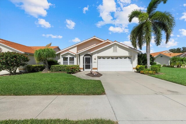 view of front of property with a garage and a front lawn