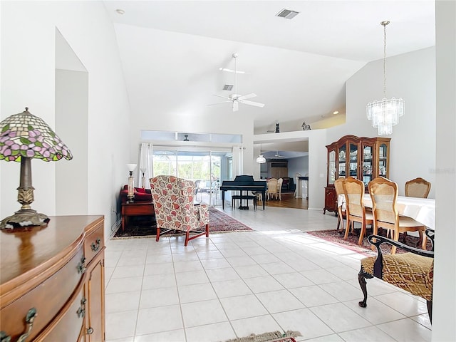 tiled living room featuring ceiling fan with notable chandelier and high vaulted ceiling