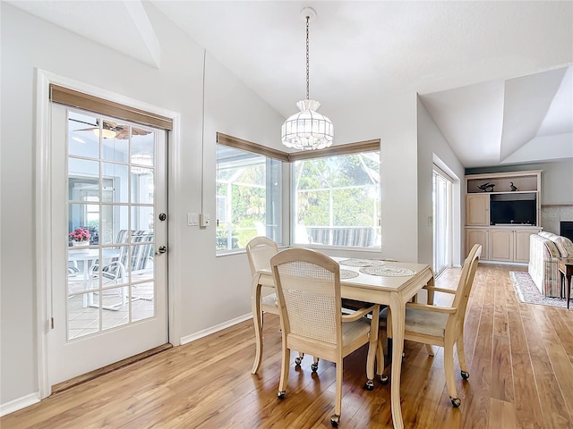 dining space featuring lofted ceiling, a wealth of natural light, and light wood-type flooring