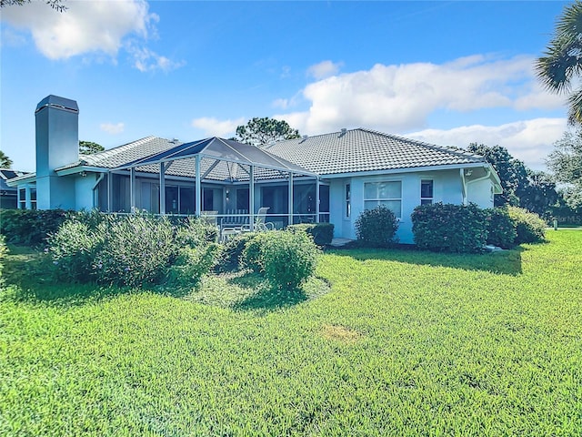 view of front of house with a lanai and a front lawn