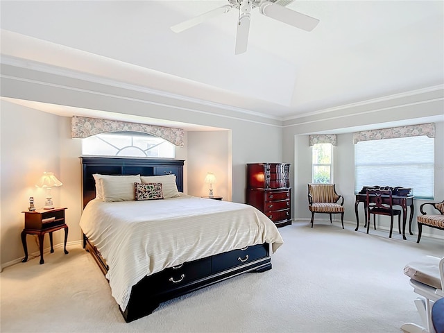 carpeted bedroom with a raised ceiling and ceiling fan