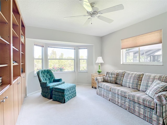 carpeted living room with a textured ceiling and ceiling fan