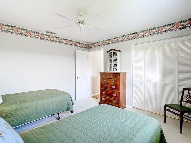 carpeted bedroom featuring ceiling fan and a closet