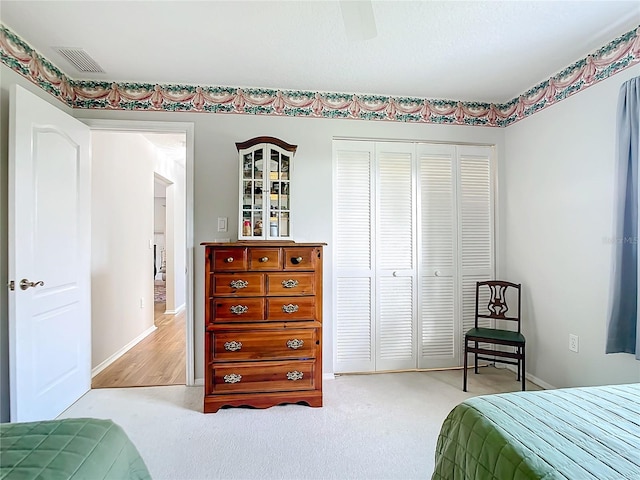 carpeted bedroom featuring ceiling fan and a closet