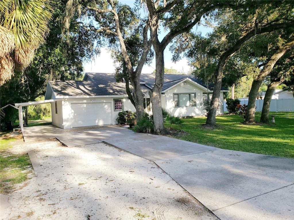 ranch-style home with a garage and a front lawn