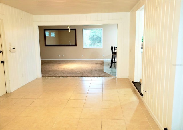 tiled spare room featuring wooden walls