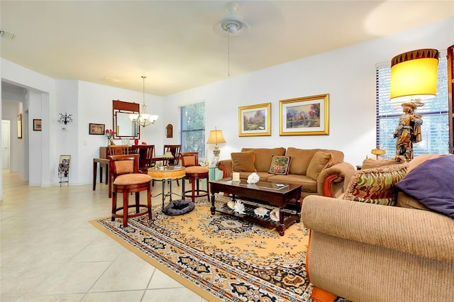 living room with light tile patterned floors, visible vents, and a notable chandelier