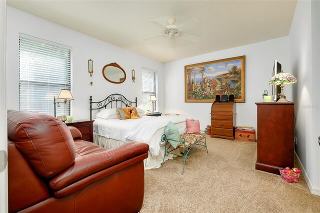 bedroom featuring baseboards, a ceiling fan, and light colored carpet