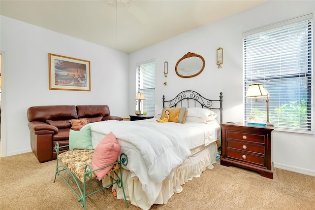 bedroom featuring light carpet and baseboards