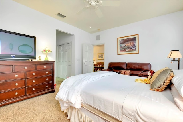 bedroom featuring light carpet, ceiling fan, visible vents, and a closet