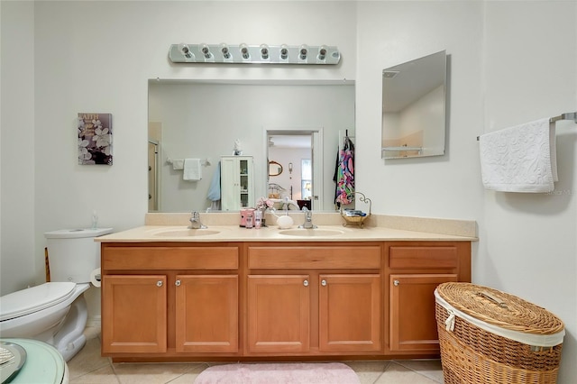 full bathroom featuring double vanity, tile patterned flooring, a sink, and toilet