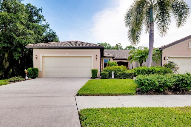 view of front of home featuring a garage, concrete driveway, a tiled roof, and stucco siding