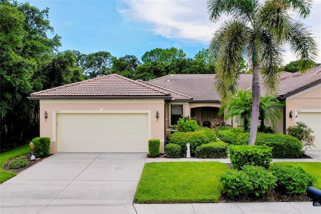 view of front of home with a garage, driveway, a tiled roof, and stucco siding