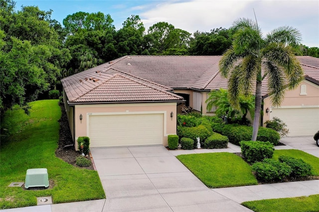 view of front of home with an attached garage, a tiled roof, concrete driveway, stucco siding, and a front lawn