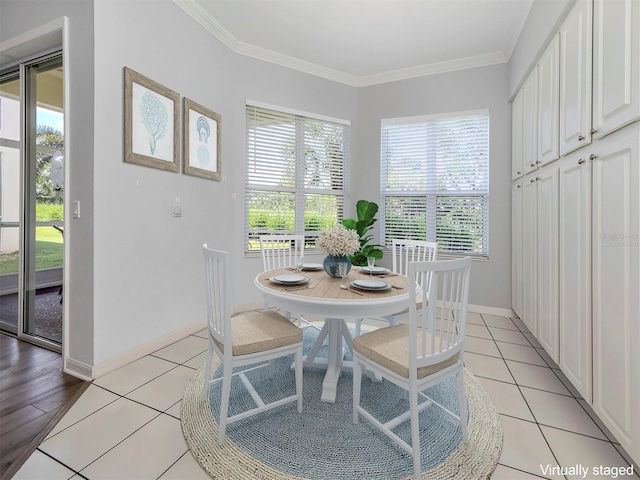 dining space with ornamental molding and light tile patterned floors