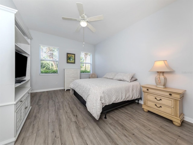 bedroom with ceiling fan, light hardwood / wood-style floors, and lofted ceiling