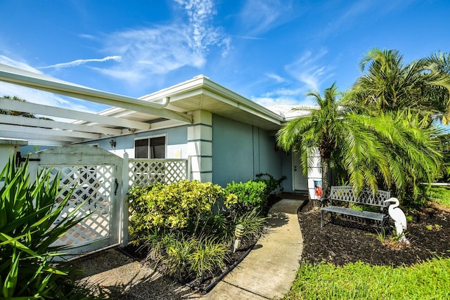 exterior space with a gate and stucco siding