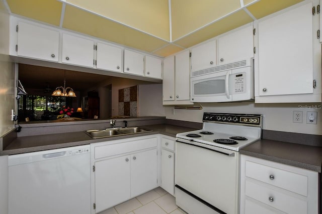 kitchen with sink, white appliances, light tile patterned floors, and white cabinets