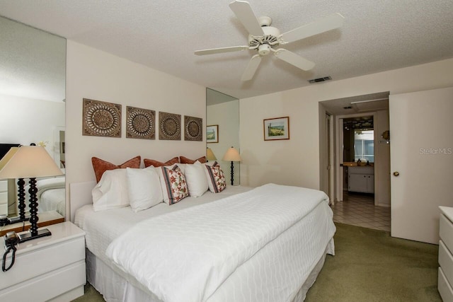 carpeted bedroom featuring a ceiling fan, visible vents, and a textured ceiling