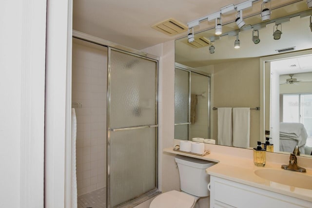 bathroom featuring vanity, toilet, ceiling fan, and walk in shower