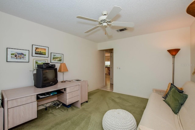 office area featuring light carpet, ceiling fan, visible vents, and a textured ceiling