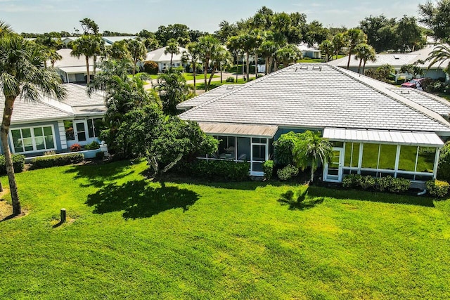 back of property with a lawn, a residential view, and a sunroom