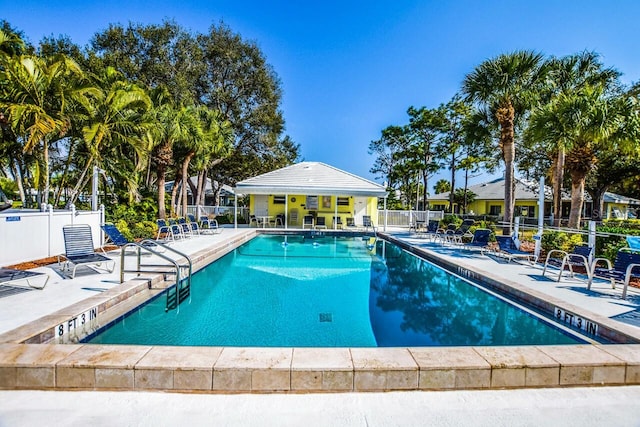 community pool featuring fence and a patio