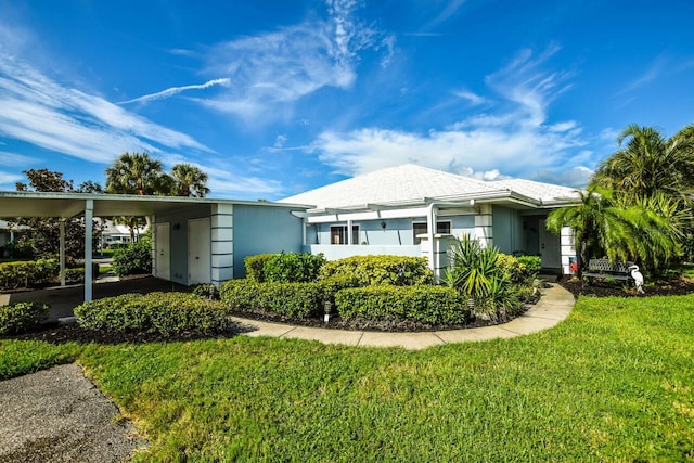 ranch-style house with a carport, a front lawn, and stucco siding