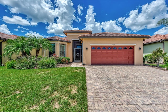 mediterranean / spanish house with a front lawn and a garage