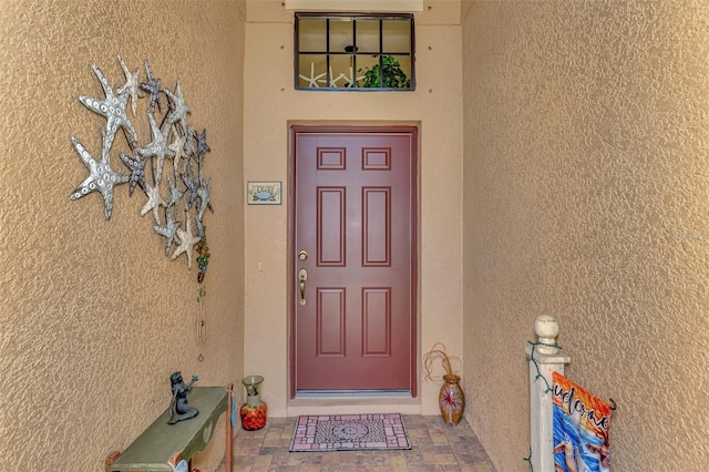 view of exterior entry with stucco siding