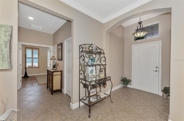 tiled foyer entrance featuring ornamental molding