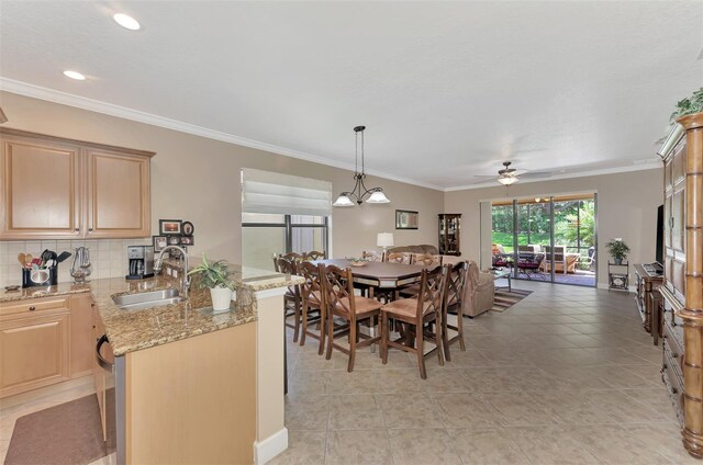 dining room featuring sink, ornamental molding, ceiling fan with notable chandelier, and light tile patterned floors