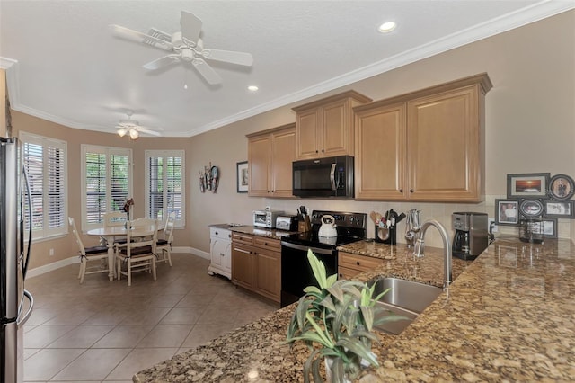 kitchen featuring light tile patterned floors, stone counters, a sink, freestanding refrigerator, and black electric range oven