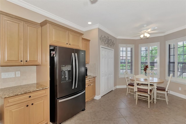 kitchen featuring crown molding, black fridge, backsplash, light stone counters, and ceiling fan