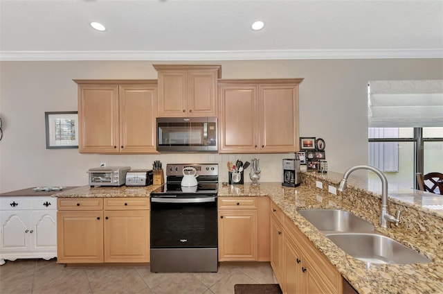 kitchen with light brown cabinets, stainless steel appliances, and a sink