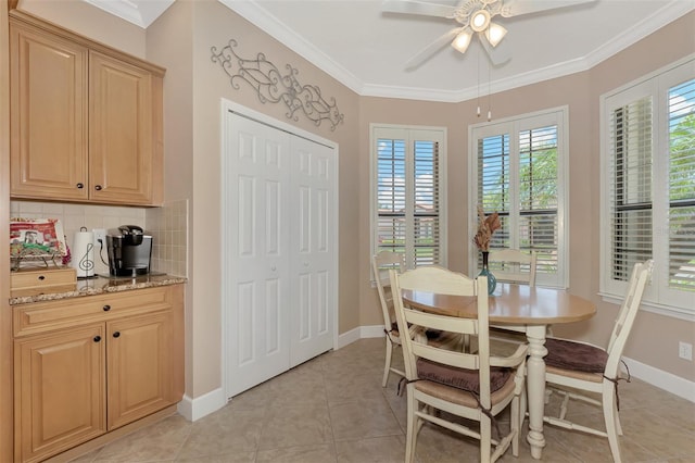 tiled dining area with ornamental molding and ceiling fan