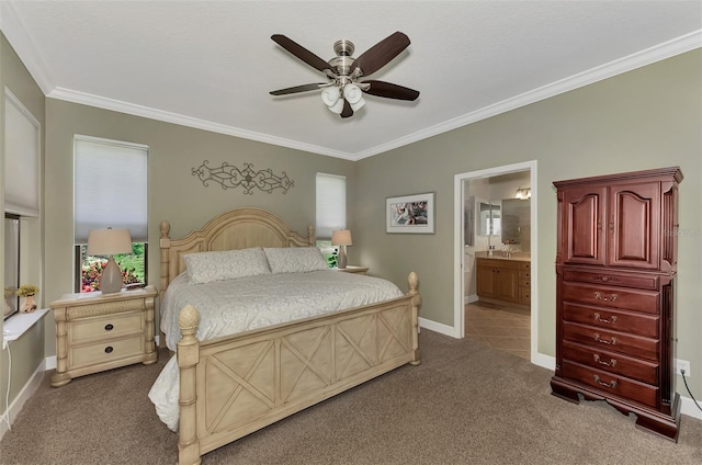 carpeted bedroom with crown molding, a ceiling fan, a sink, ensuite bath, and baseboards