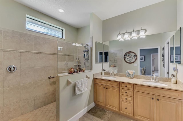 full bath featuring ensuite bathroom, double vanity, tile patterned flooring, and a sink