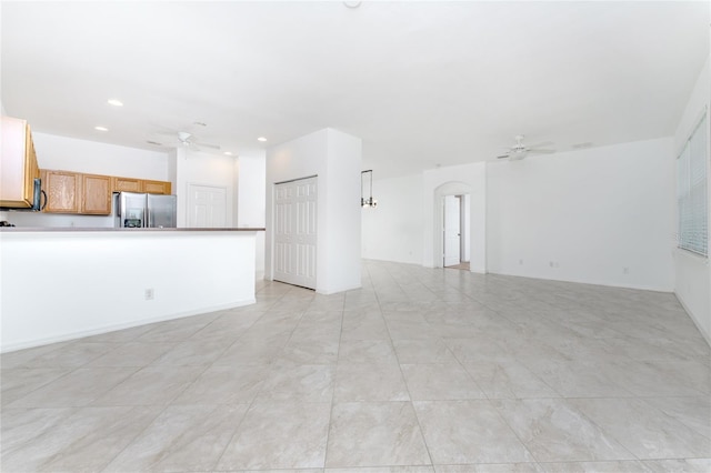 unfurnished living room featuring ceiling fan