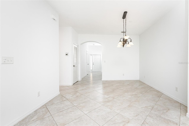 spare room with an inviting chandelier