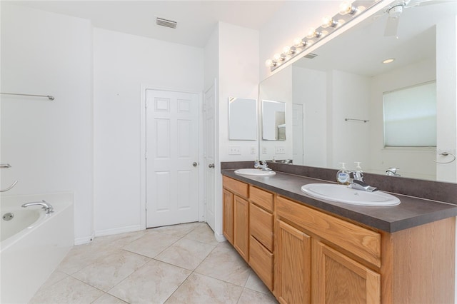 bathroom featuring vanity, a tub to relax in, and tile patterned floors