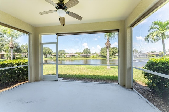 unfurnished sunroom with a water view, plenty of natural light, and ceiling fan