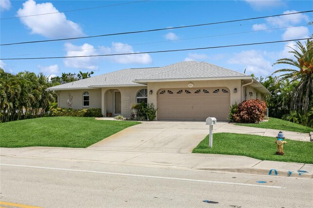 ranch-style house featuring a garage and a front lawn