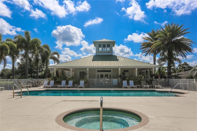 view of swimming pool featuring a hot tub and a patio