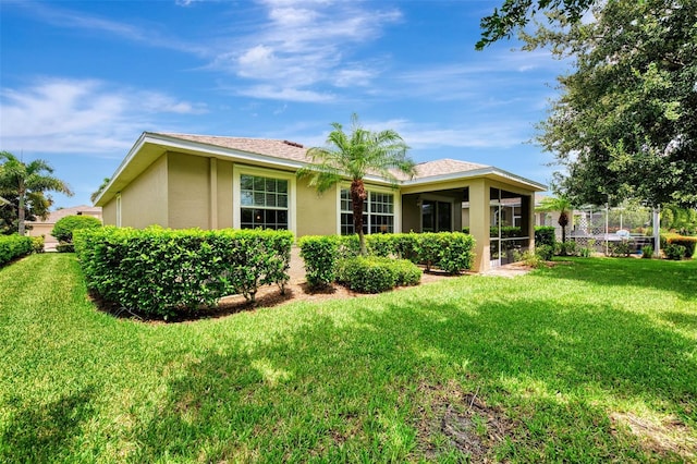 back of house with a yard and a sunroom