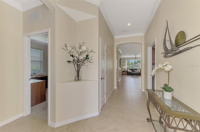 corridor featuring ornamental molding and light tile patterned floors