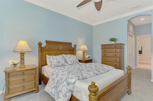 bedroom featuring ornamental molding, light colored carpet, ceiling fan, and a closet