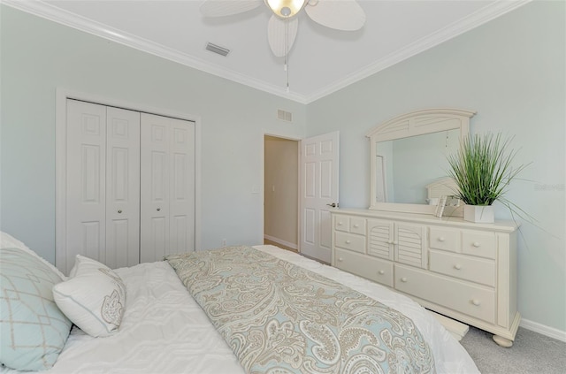 carpeted bedroom with ornamental molding, ceiling fan, and a closet