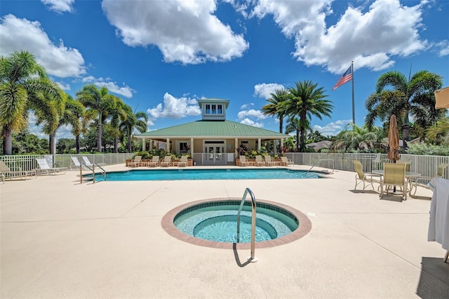 view of swimming pool featuring a patio, a hot tub, and french doors