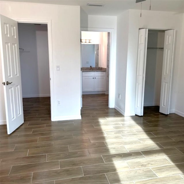 unfurnished bedroom featuring ensuite bathroom and a closet